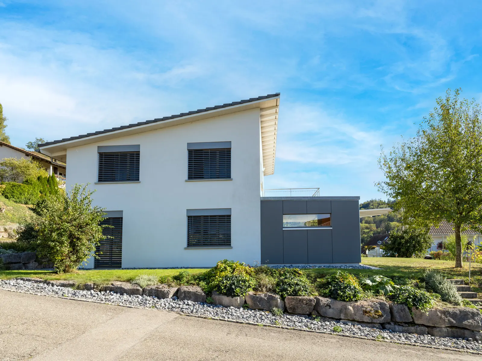 Einfamilienhaus in Etzgen mit angebautem Wintergarten in anthrazitfarbener Faserzementfassade, Kanton Aargau.