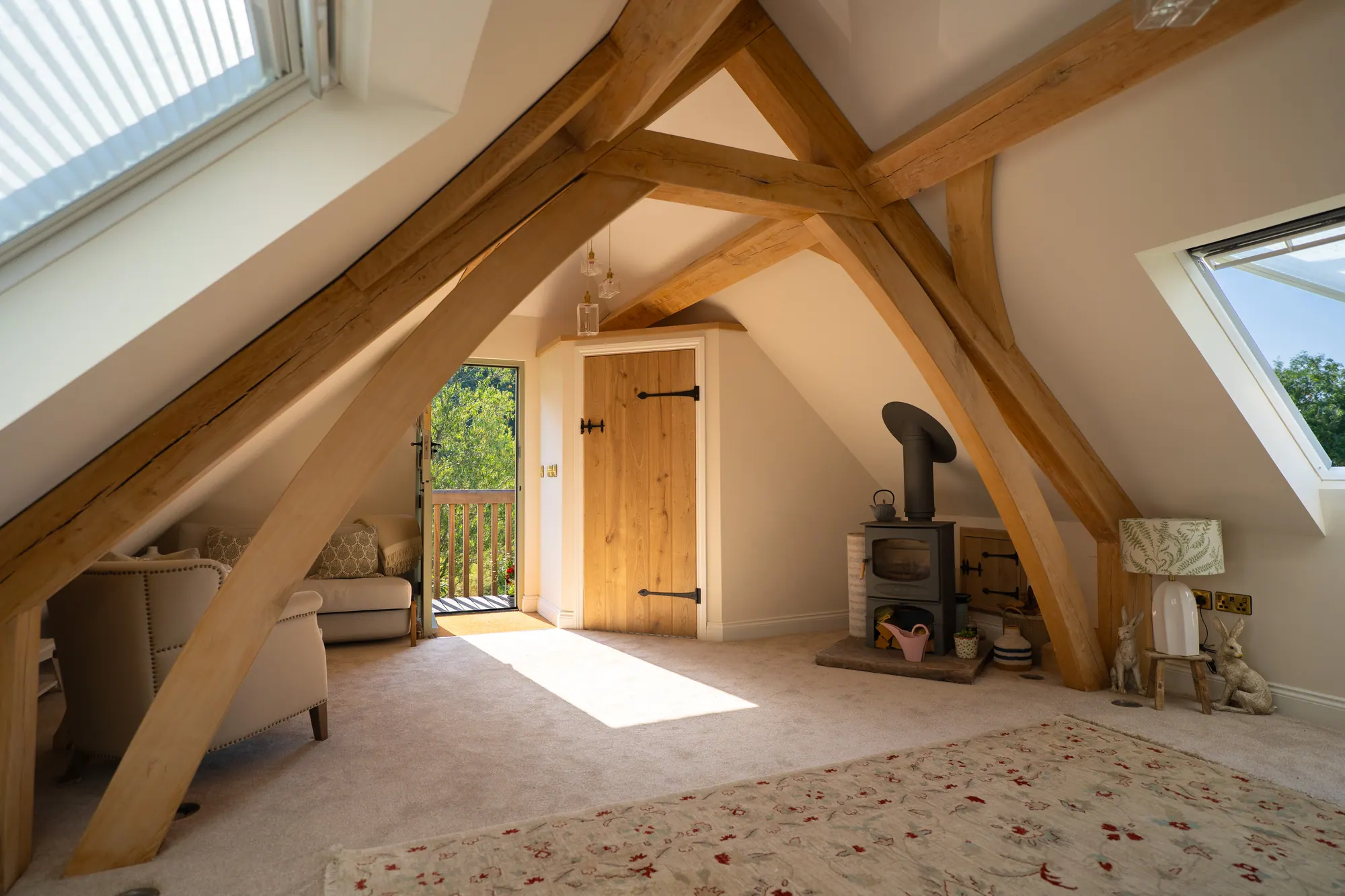Room over the oak frame garage at Crickhowell, with exposed oak trusses and a wood burner