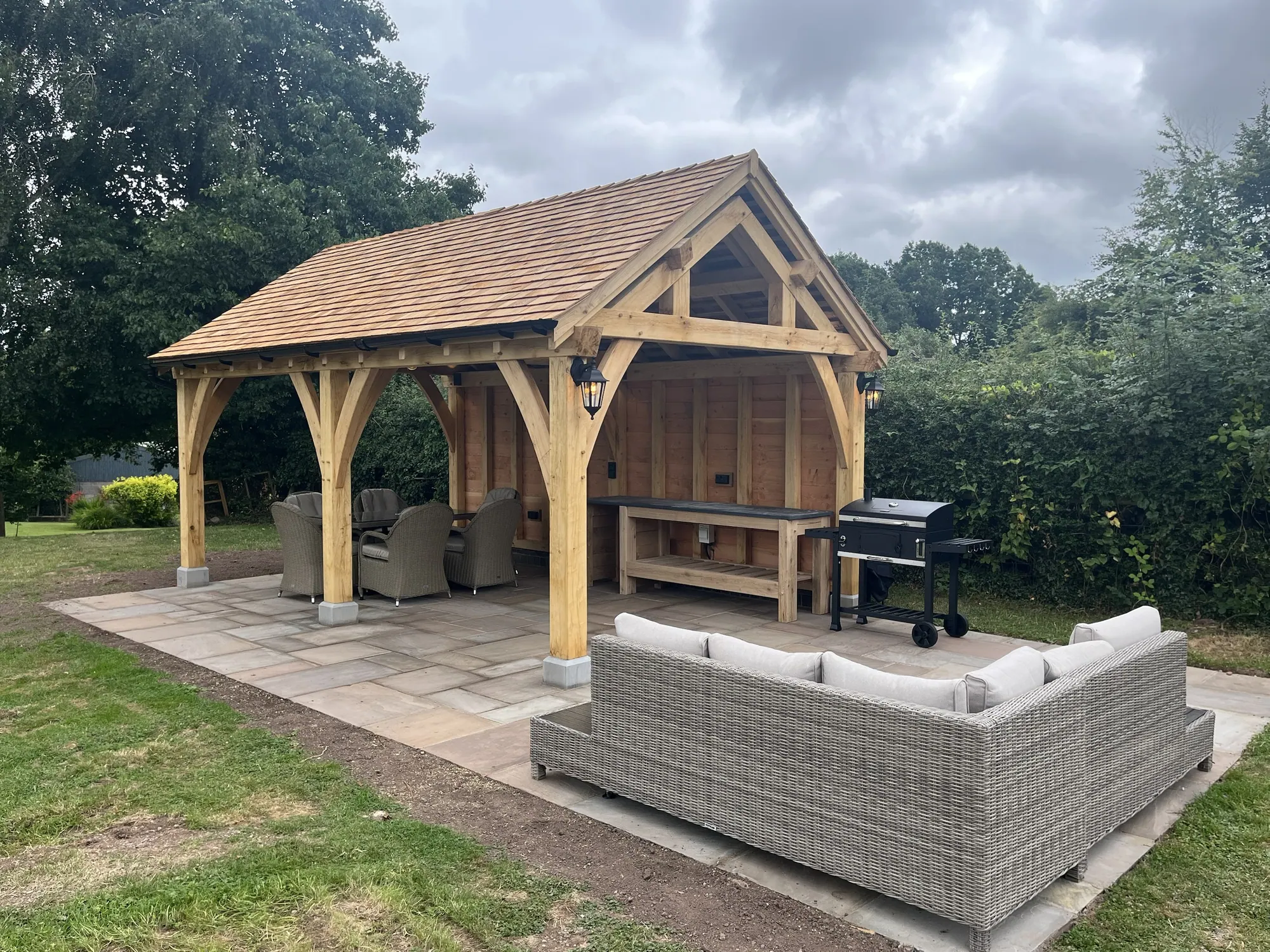 Oak garden pavilion with a cedar shingle roof and an outdoor kitchen in the closed bay, at Woods Farmstead, Raglan