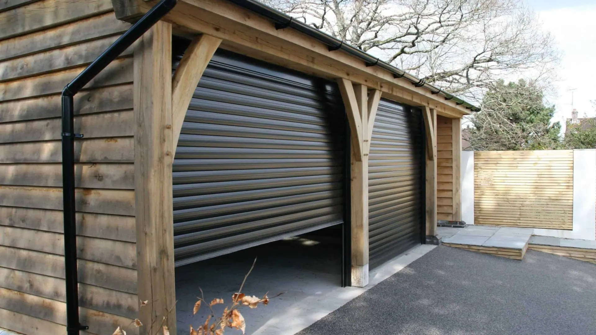 Caerleon: oak feather-edge cladding and Spanish slate on the three-bay garage