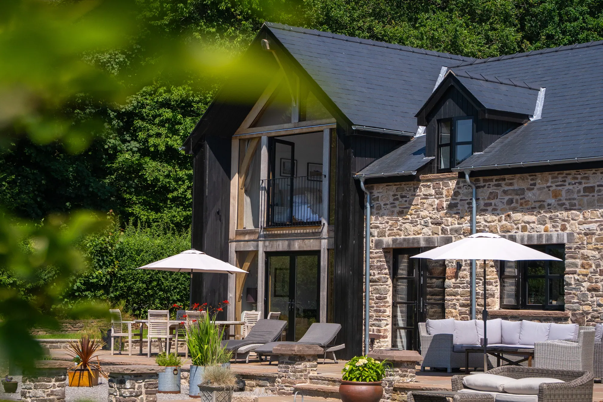 The two-storey glazed oak gable of the self-built house at Llanbedr, near Crickhowell, above the terrace.