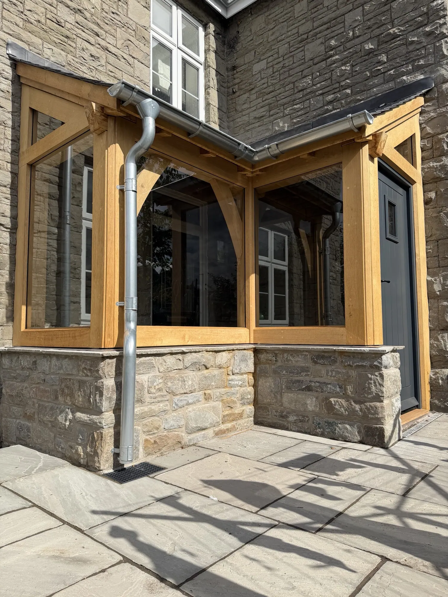Glazed oak corner porch on a stone farmhouse in Crickhowell, scribed to the existing wall