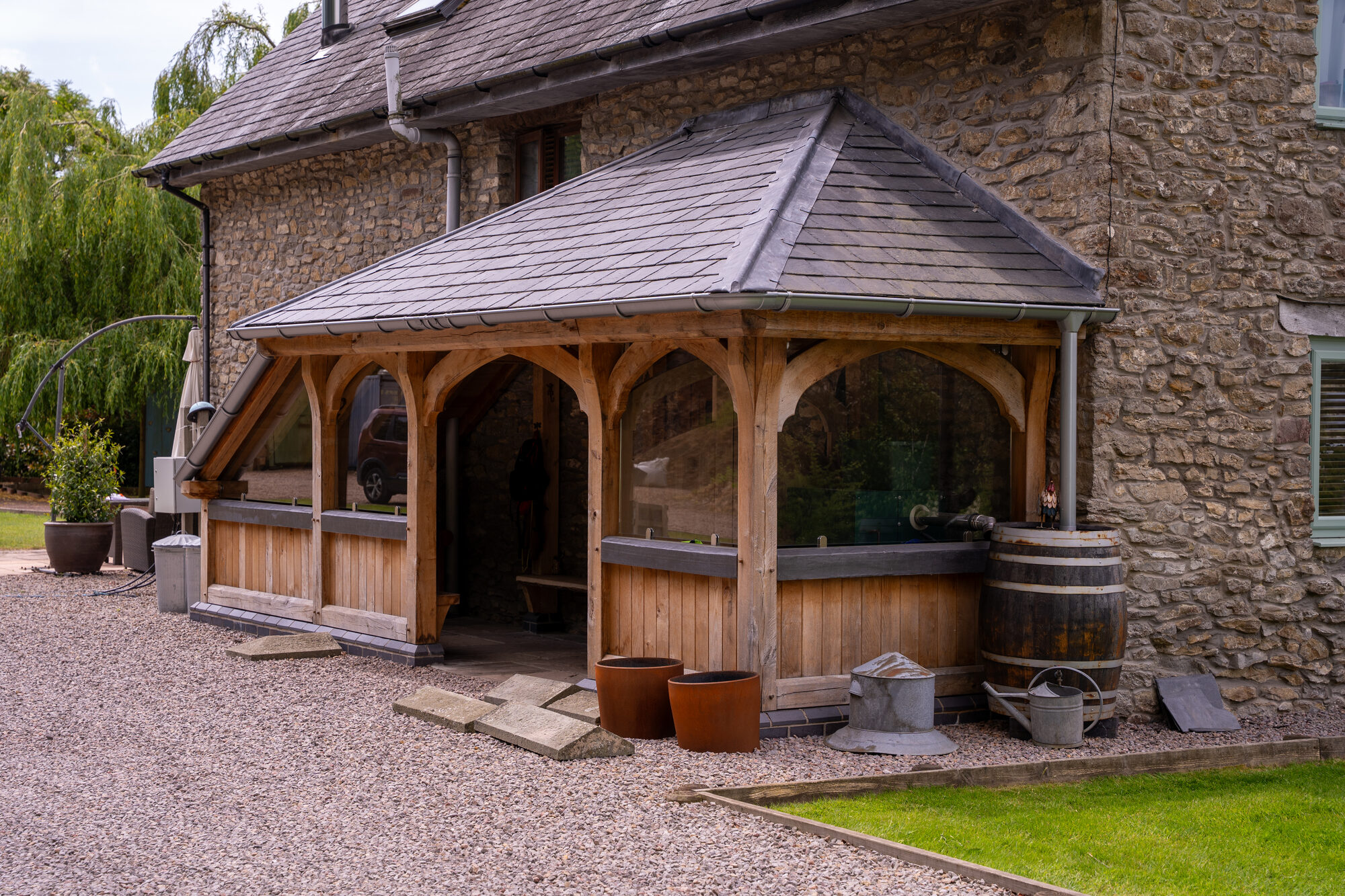 Oak frame porch with arched openings and board cladding, Usk