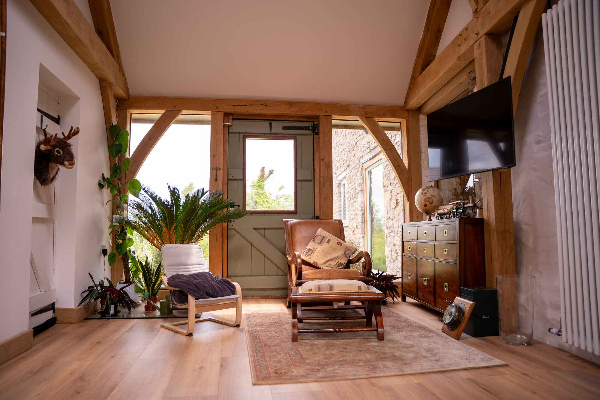 Oak frame link between two stone barns at Usk, glazed on both sides and used as a home office