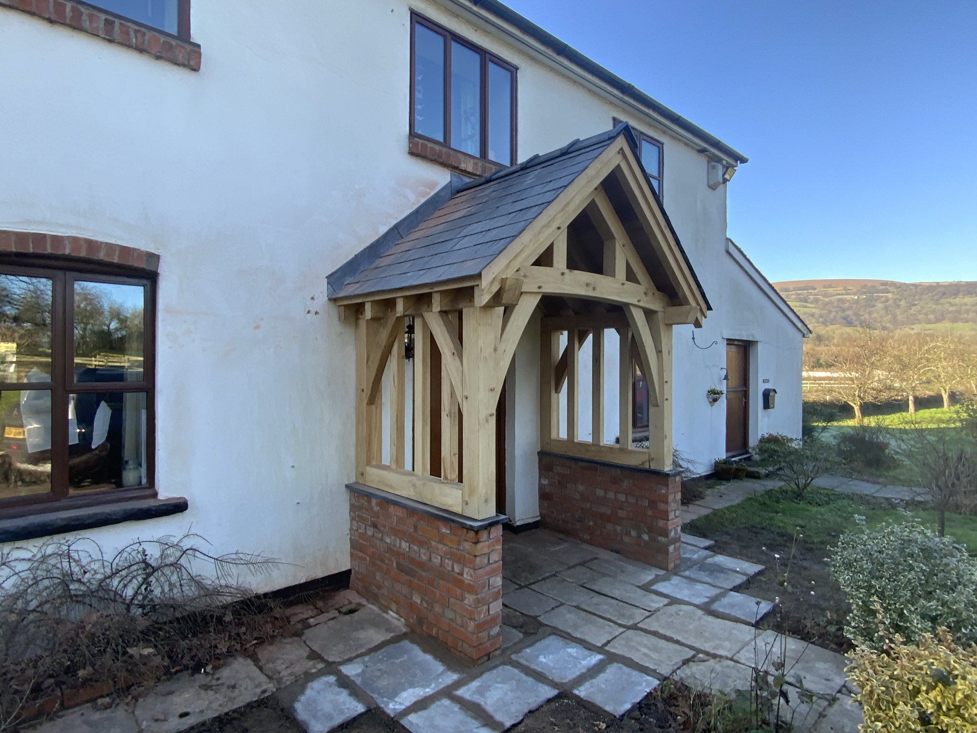 Side view of an oak gable porch at Mamhilad, showing the oak balustrade over the brick plinth