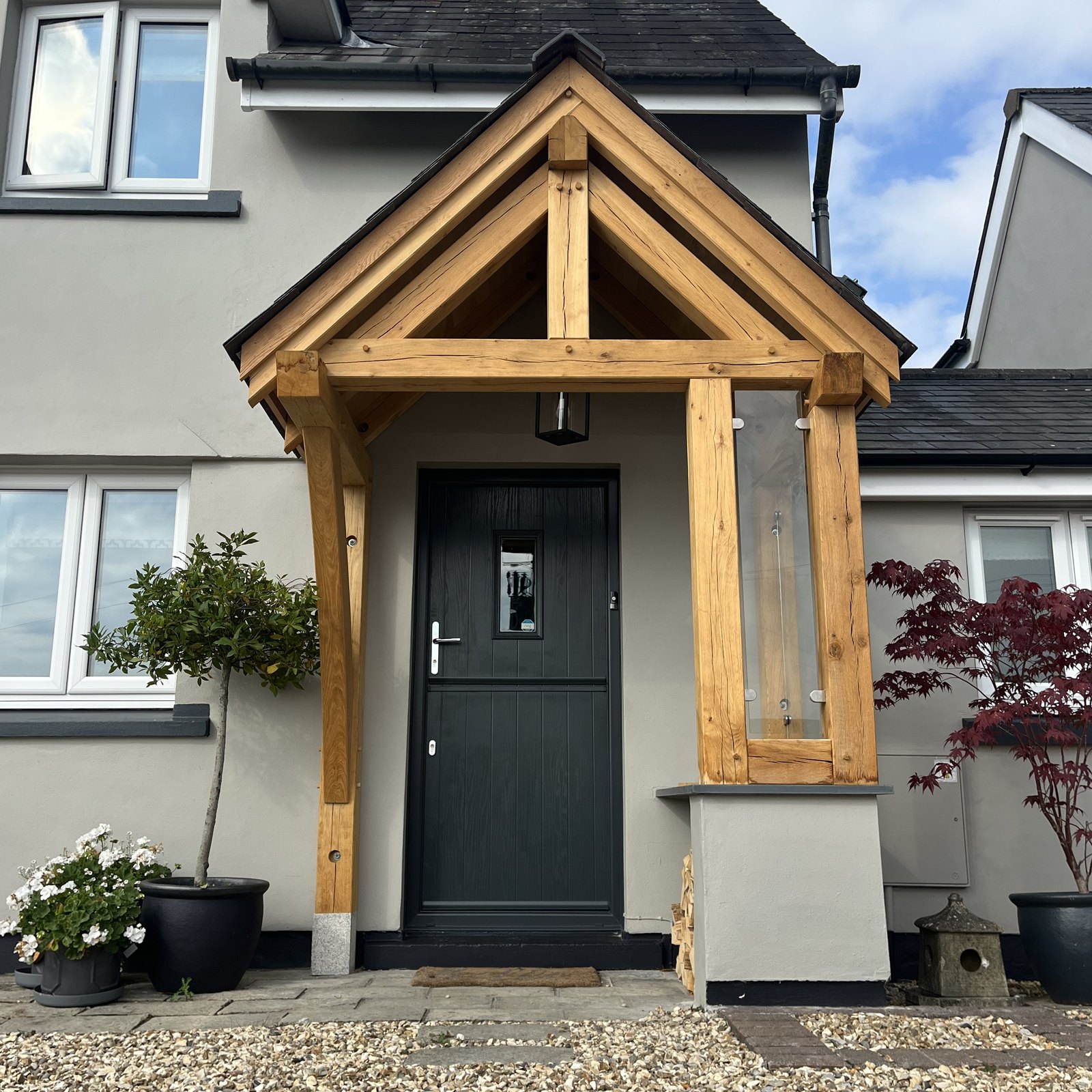 Oak gable porch over a dark grey front door, glazed on one side