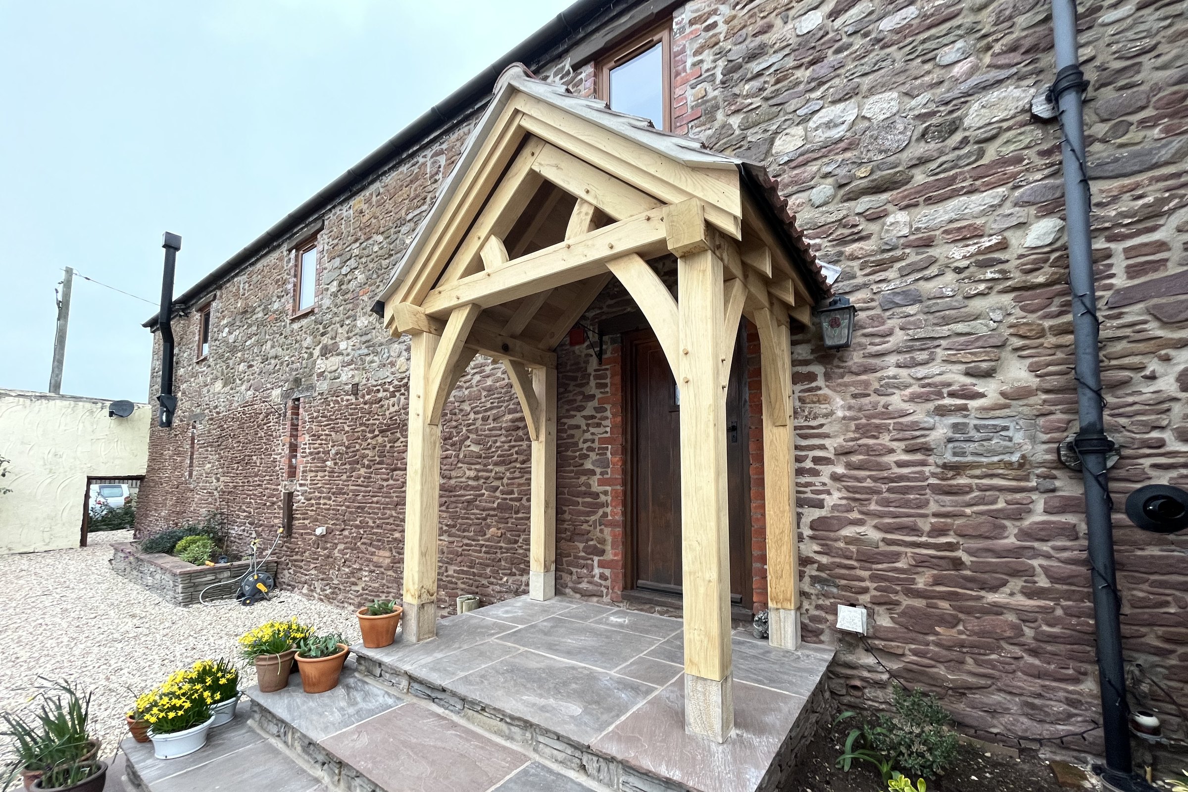Oak gable porch with a tiled roof on a stone barn at Llantilio Crossenny