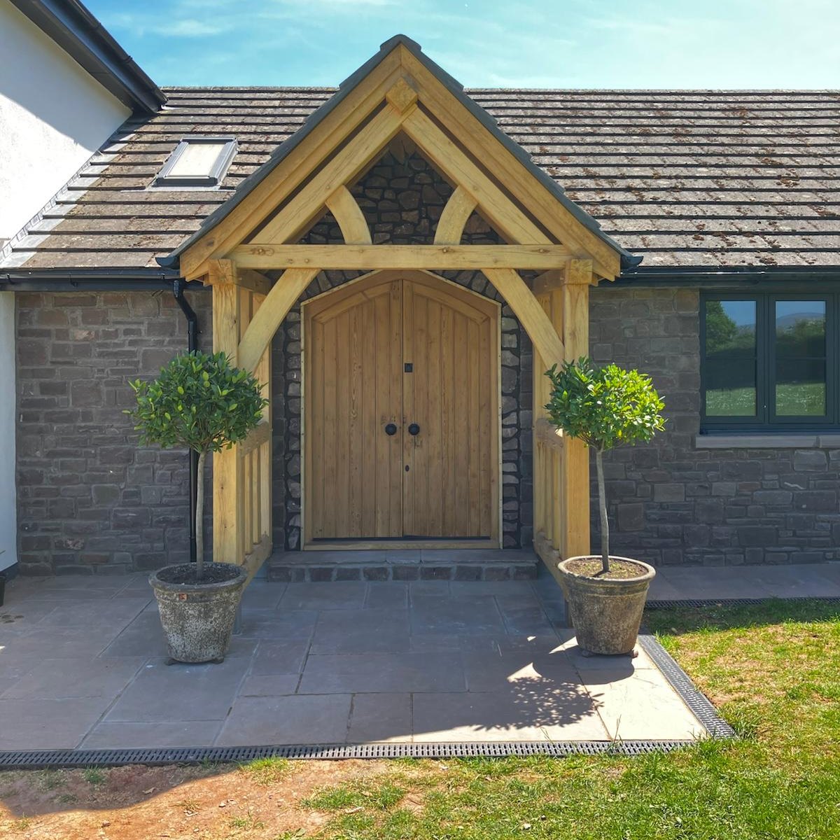 Oak gable porch with double oak doors on a stone house