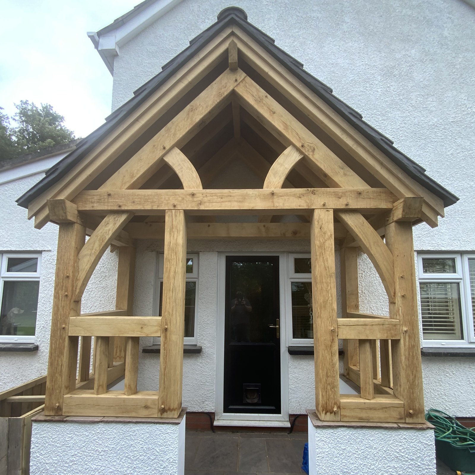 Oak gable porch with curved braces and balustrade sides