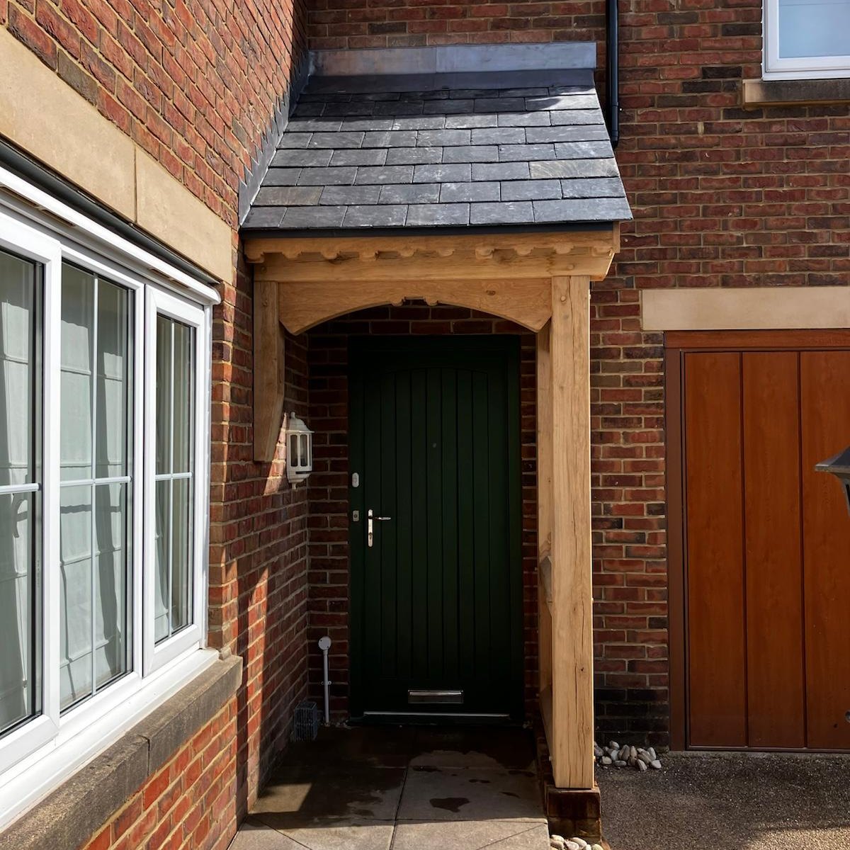Oak gable porch over a green front door
