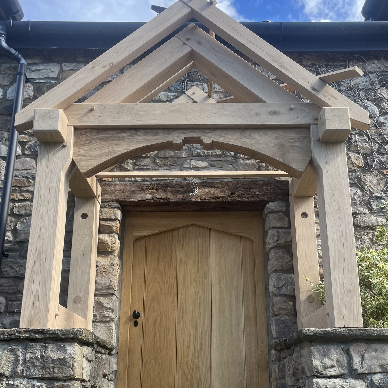 Oak gable porch on stone plinths over an oak front door