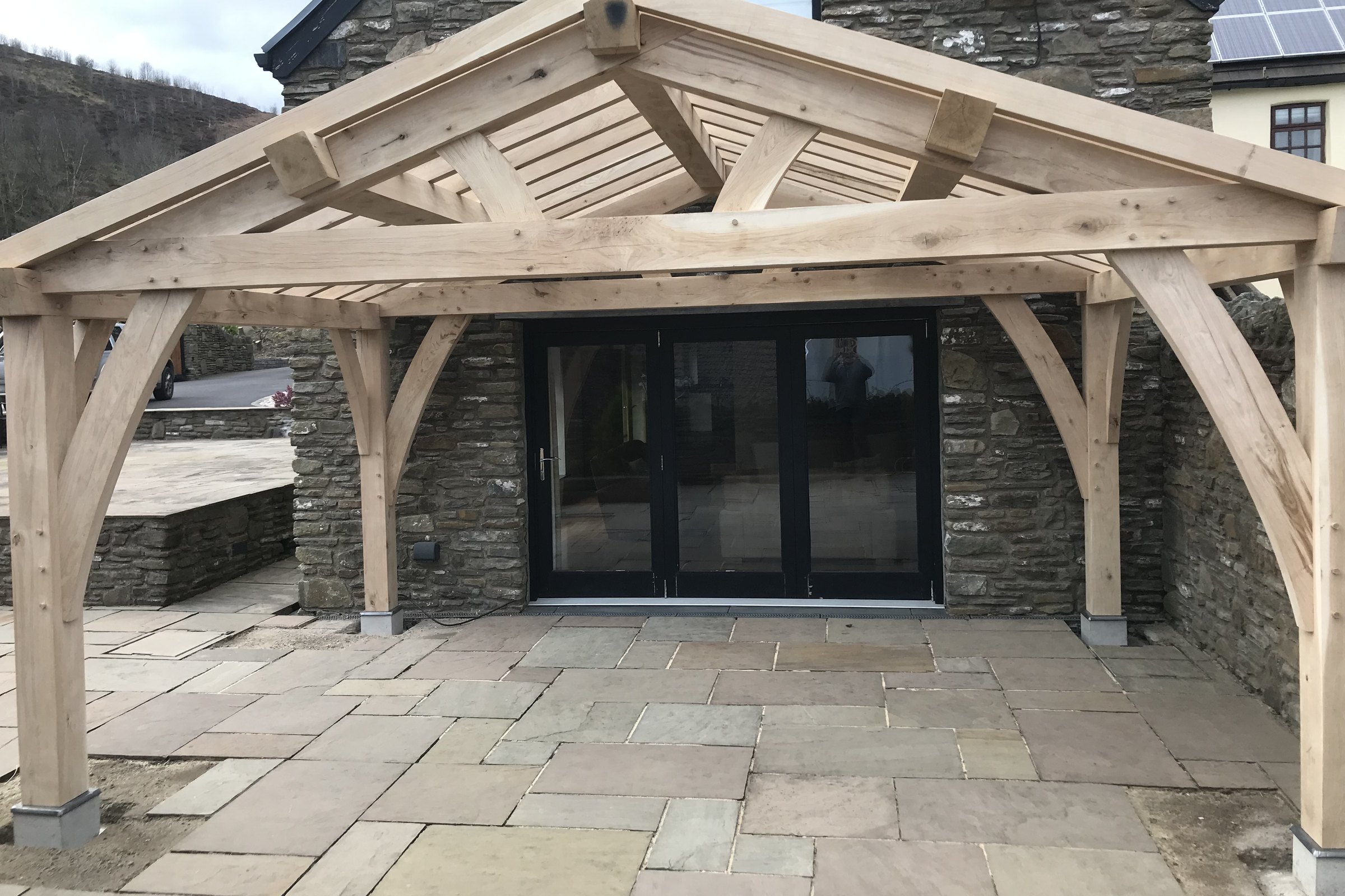Oak frame garden pavilion on a stone-walled terrace at Ferndale