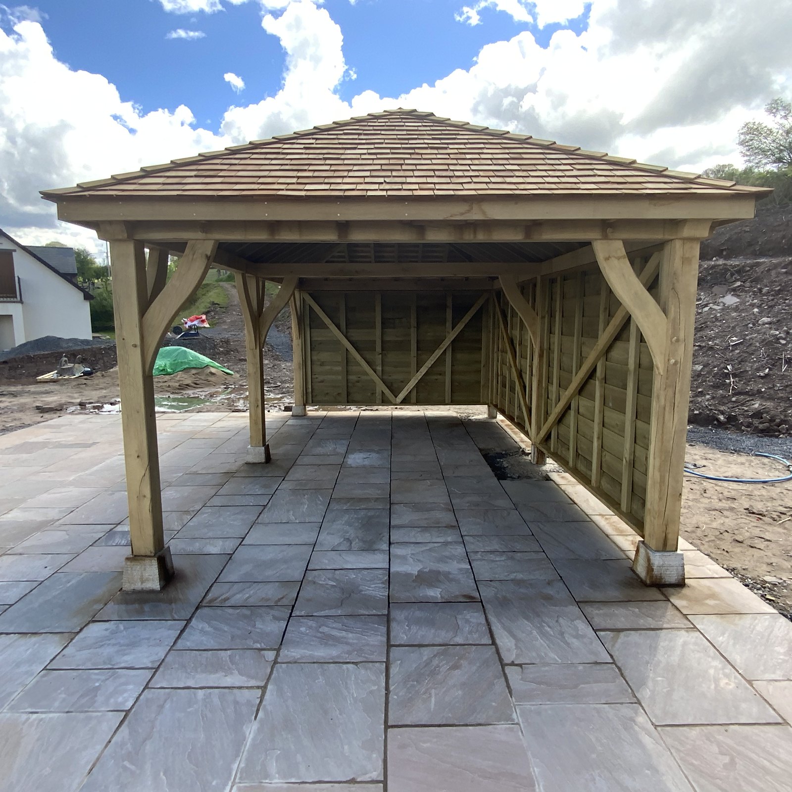 Oak frame gazebo with curved braces and a shingle roof