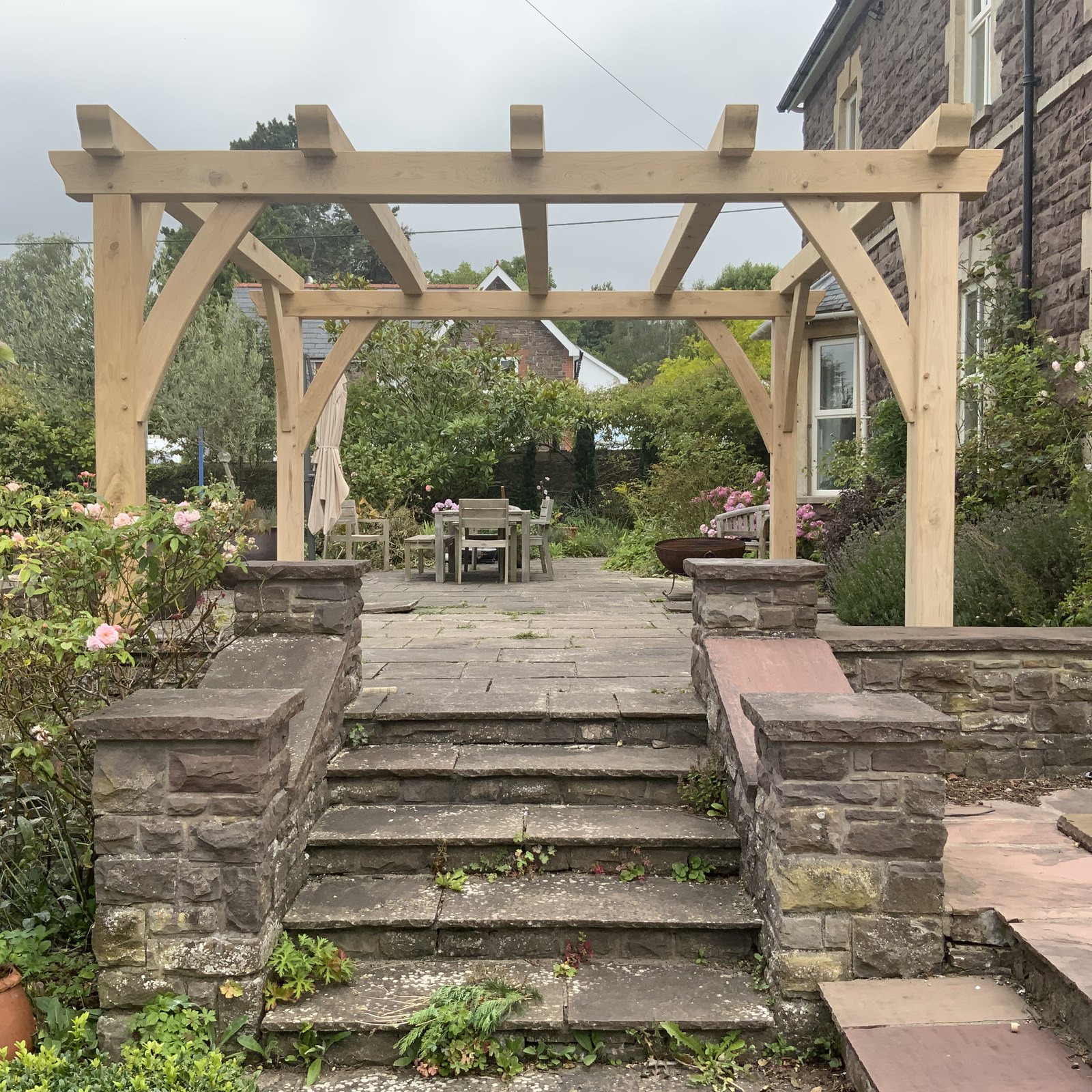 Oak pergola at the top of stone garden steps