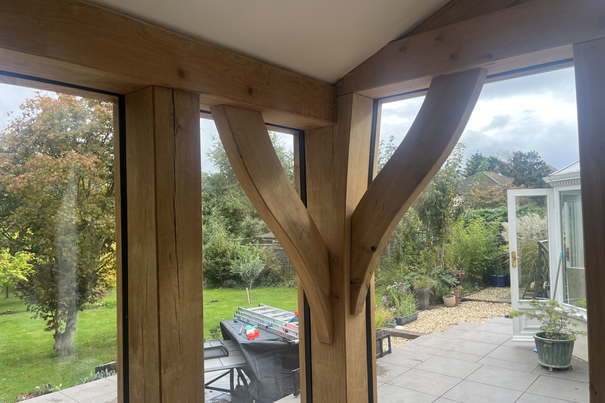 Inside a glazed oak room, looking out to the garden