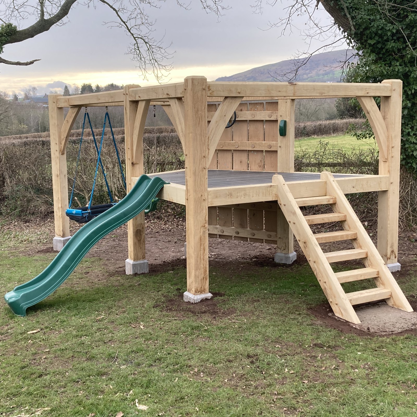 Oak play structure with a slide and ladder