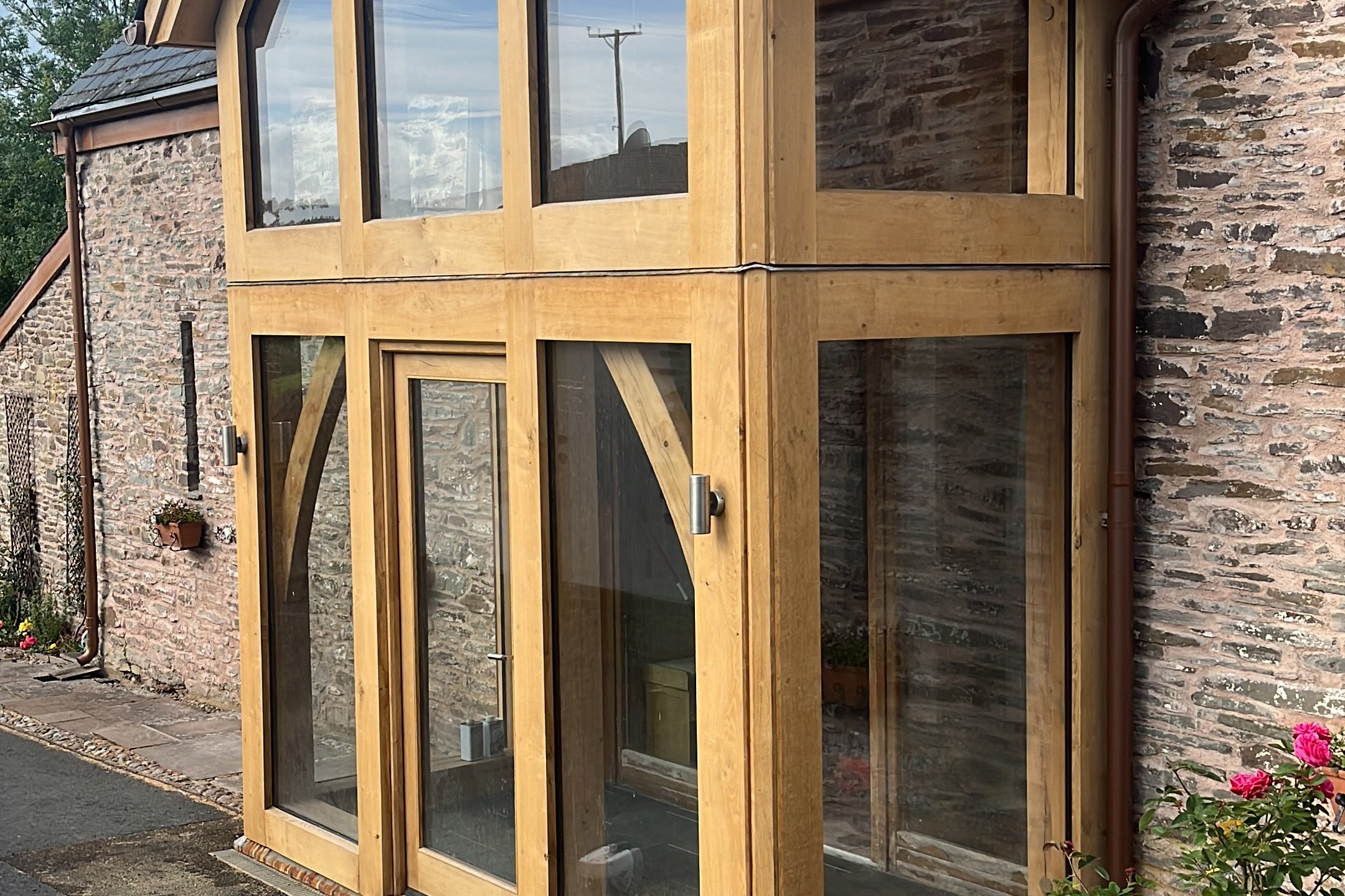 Glazed oak gable extension on a stone barn in Brecon