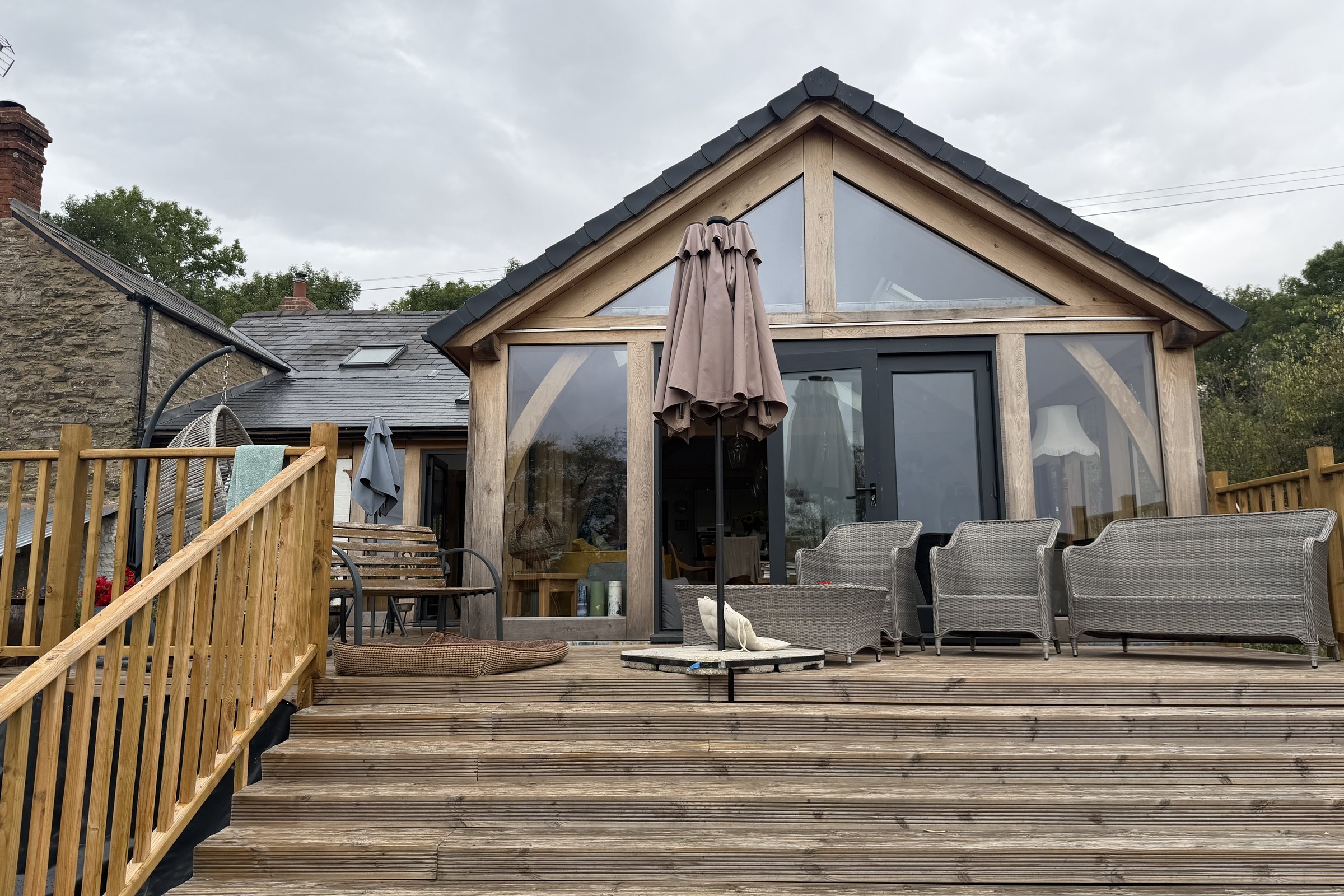 Oak frame garden room with a glazed gable over a deck