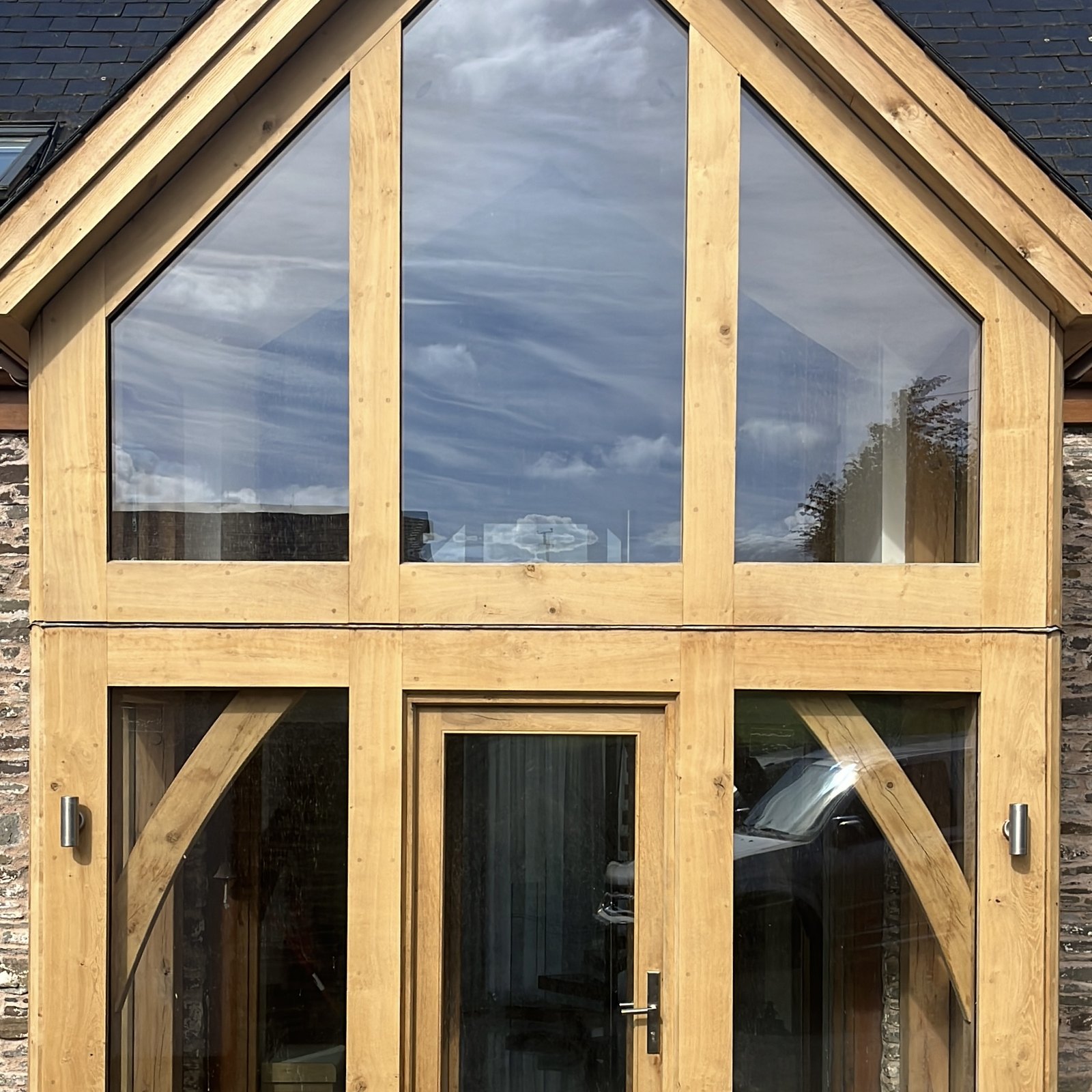 Fully glazed oak gable on a stone barn