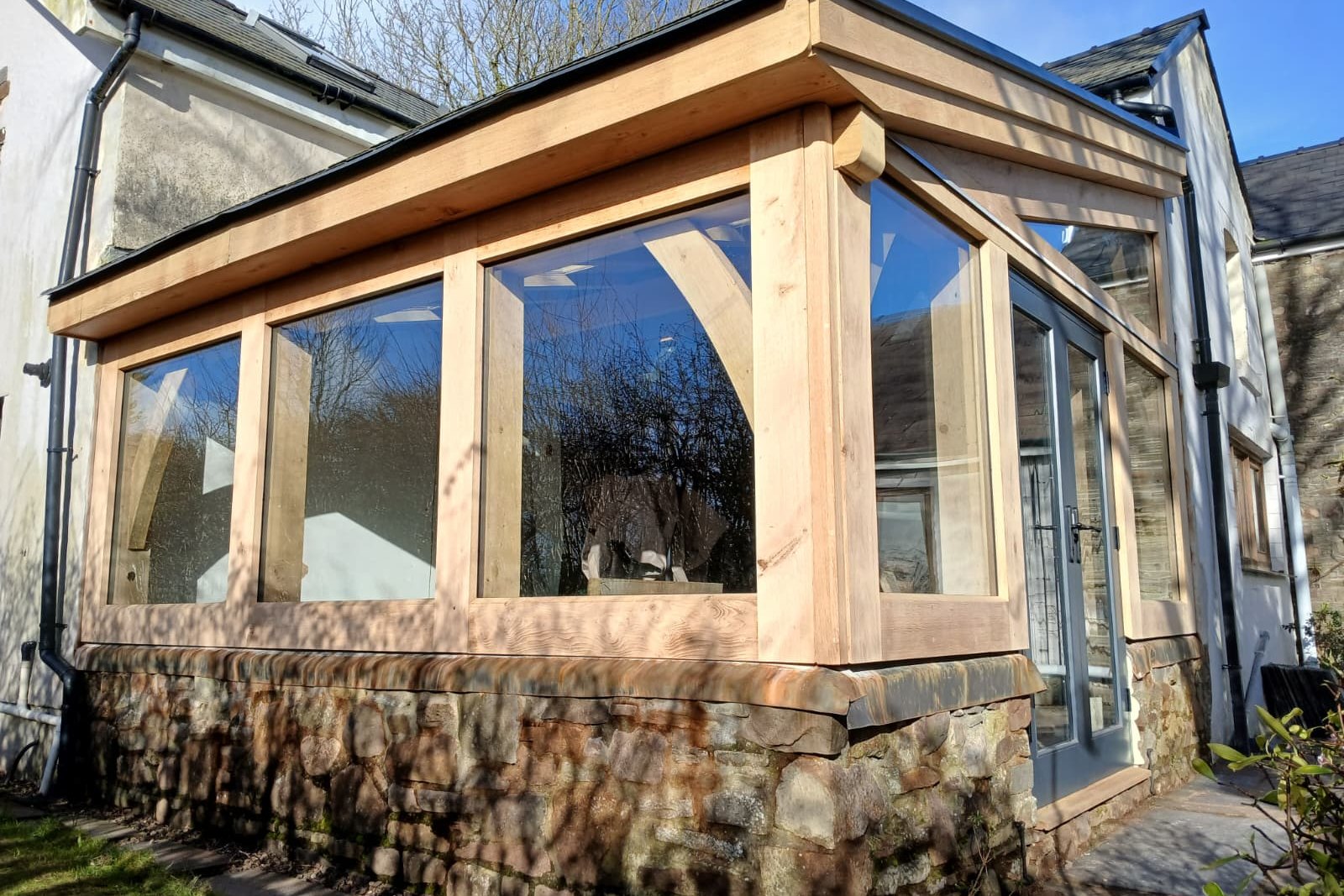 Oak garden room with a stone plinth and glazed sides