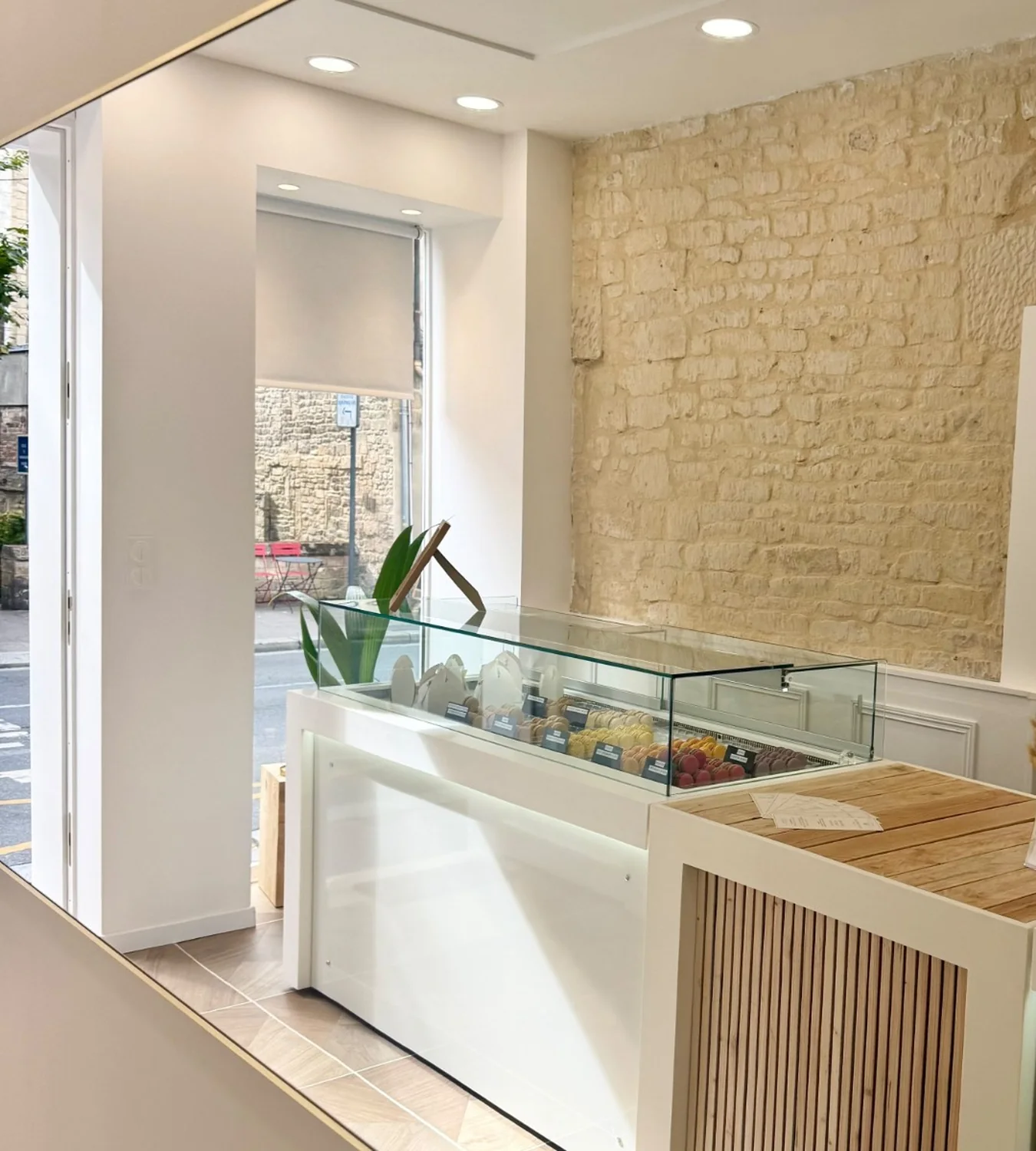 Comptoir et vitrine de macarons de la boutique Maison Derollier, vue vers la rue.