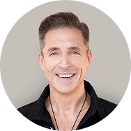 Smiling middle-aged man with short brown hair wearing a black shirt and necklace.