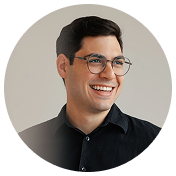 Smiling man with glasses and black shirt looking to the side in a circular frame.
