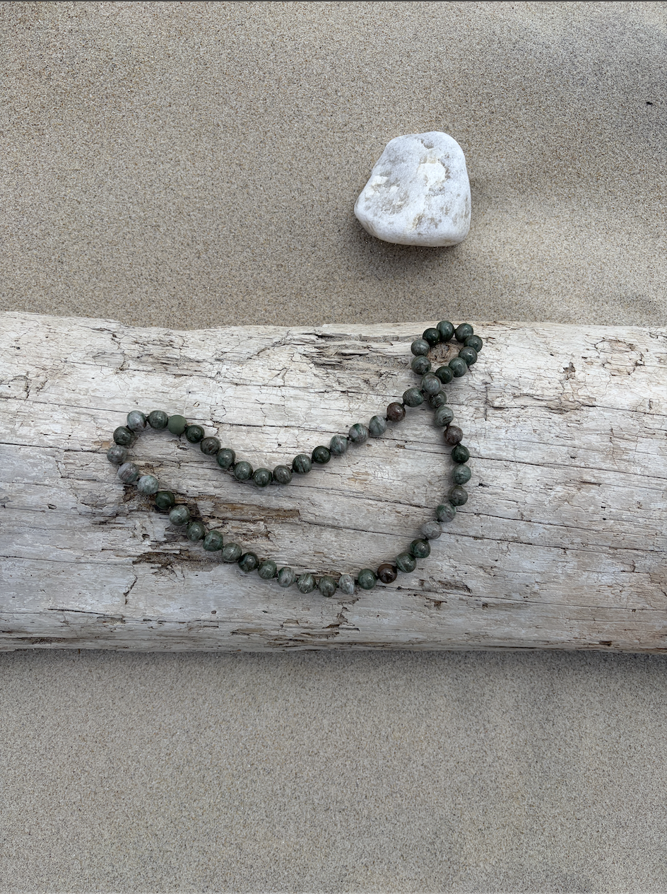 Jade mala on driftwood