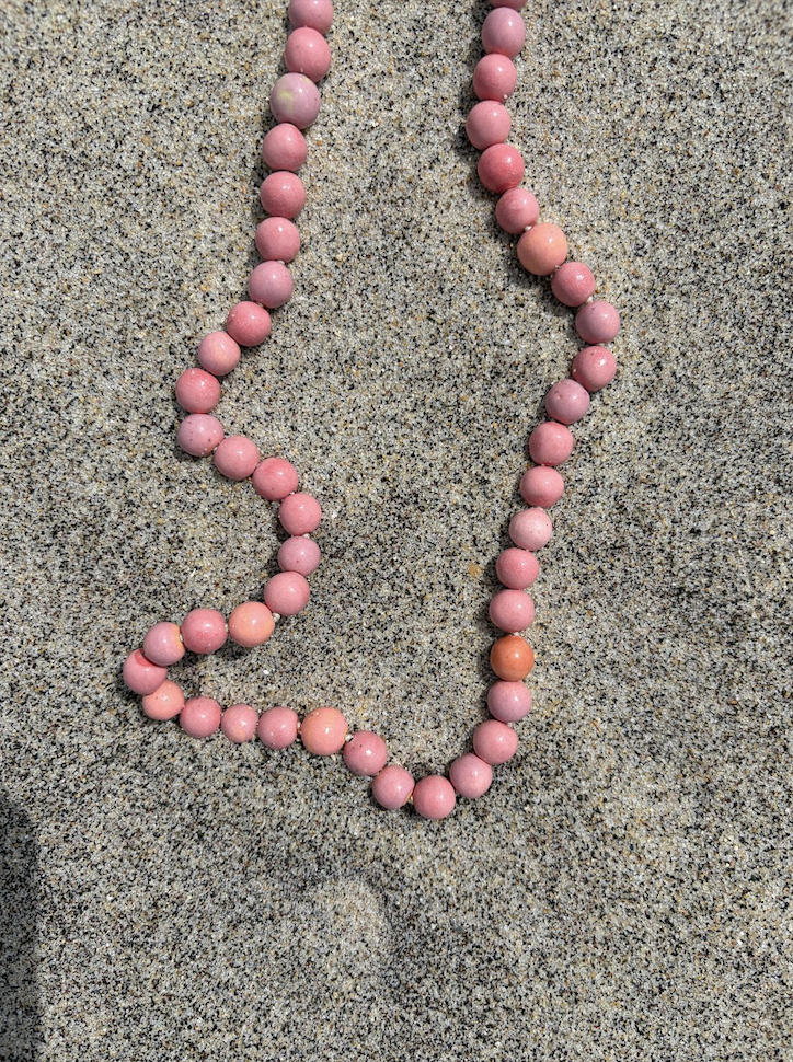 Jade mala on driftwood close