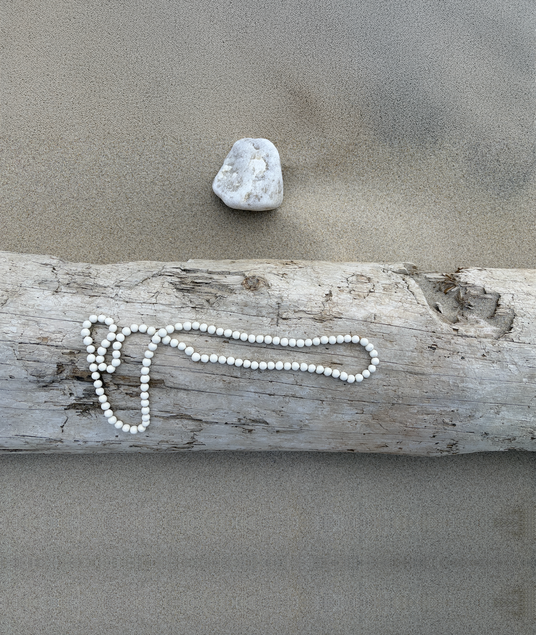 Eggshell mala on driftwood