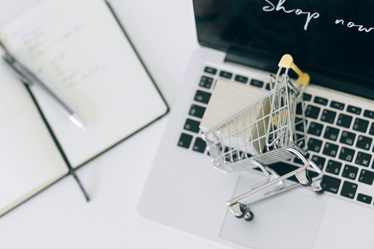 Miniature shopping cart on a laptop — eCommerce growth stack