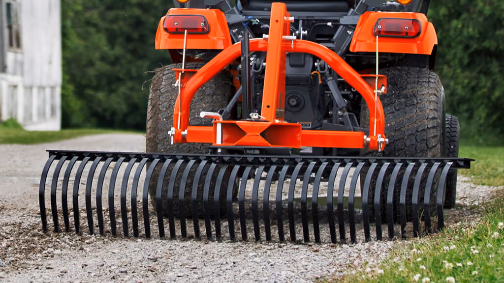 Orange rake attachment with rows of steel tines.