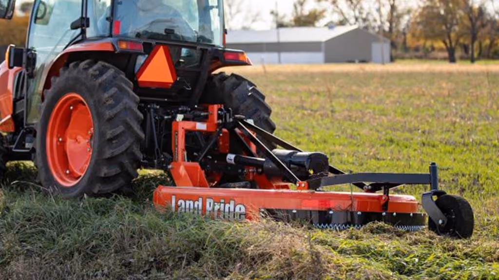 Orange rotary cutter attachment for pasture and field mowing.