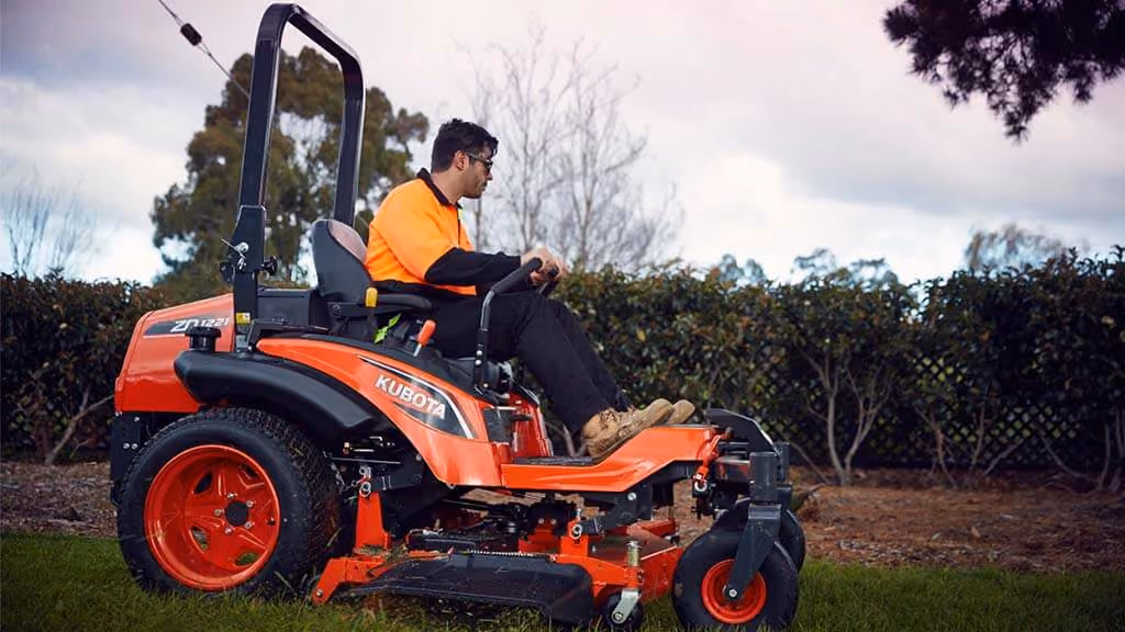 Orange Kubota mower with cutting deck.