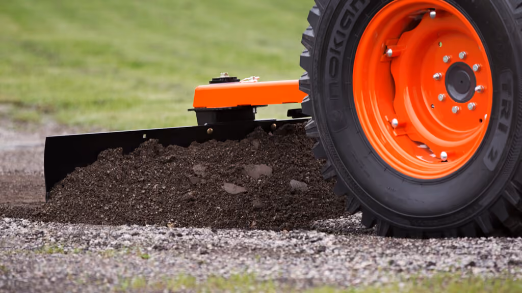 Orange grading attachment with wide steel blade.