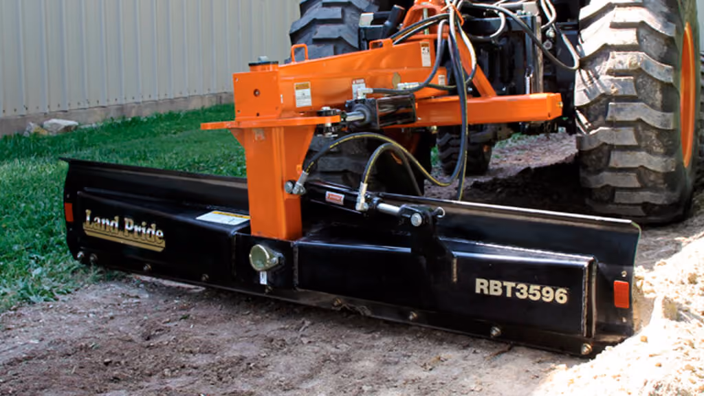 Orange grading attachment with wide steel blade.