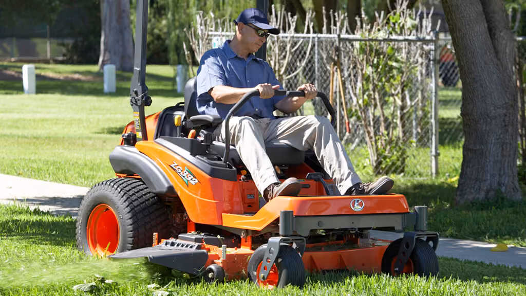 Orange Kubota mower with cutting deck.