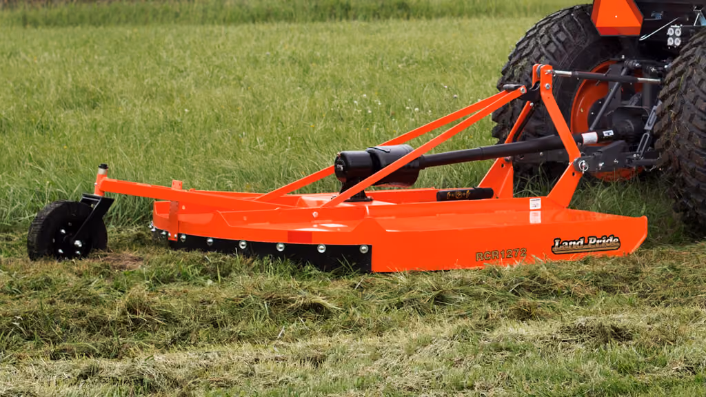 Orange rotary cutter attachment for pasture and field mowing.
