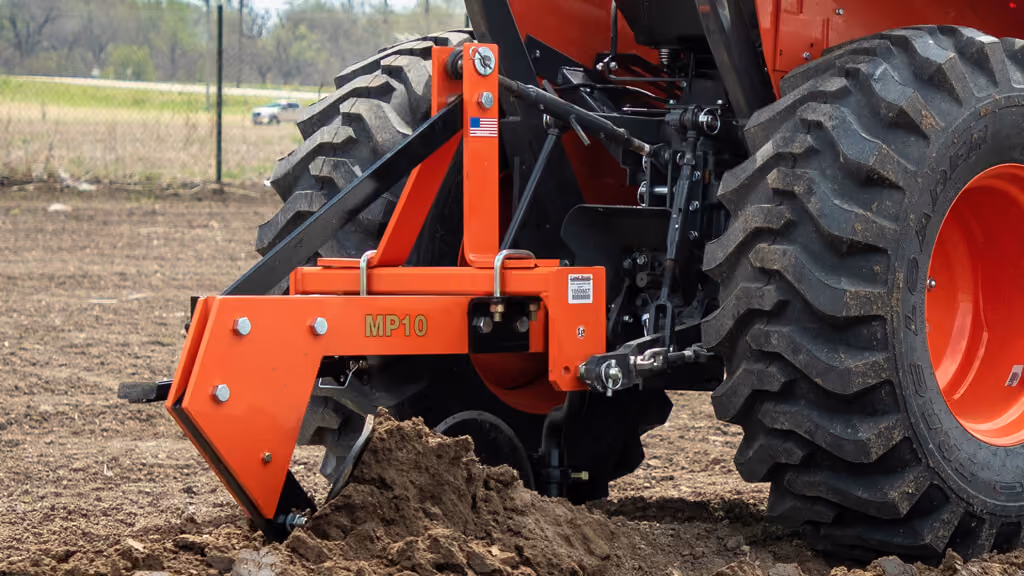Orange mouldboard plough attachment with curved steel blades.