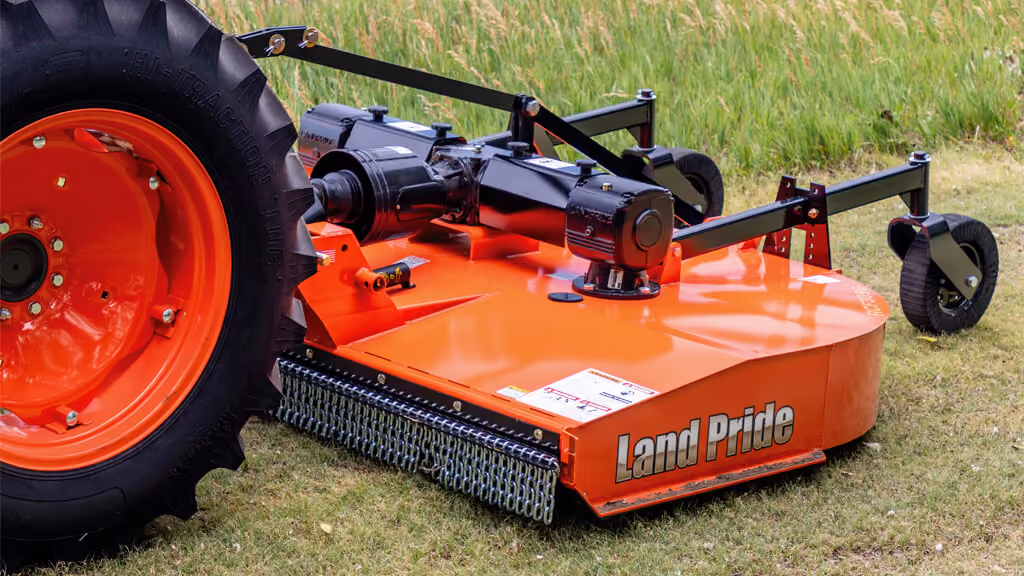 Orange rotary cutter attachment for pasture and field mowing.