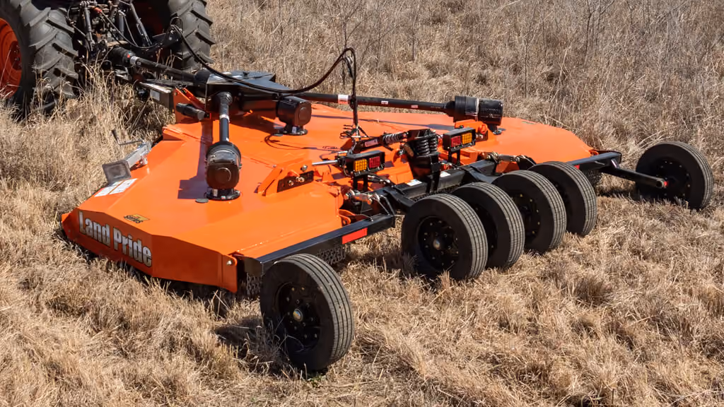 Orange rotary cutter attachment for pasture and field mowing.