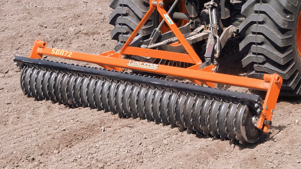 Orange seeder attachment for preparing and planting soil.