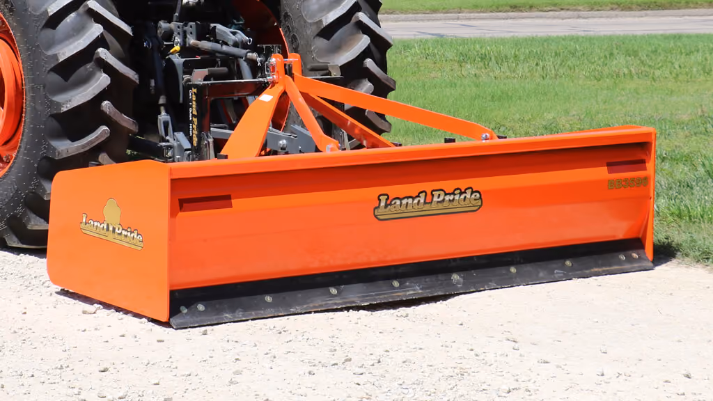 Orange grading attachment with wide steel blade.