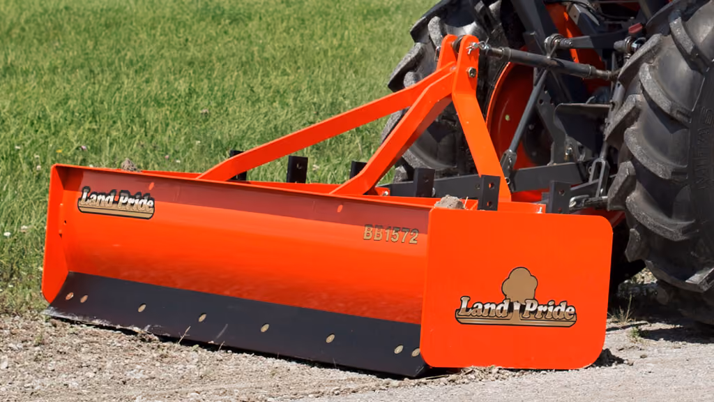 Orange grading attachment with wide steel blade.