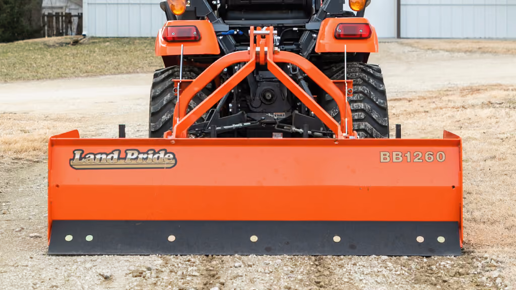 Orange grading attachment with wide steel blade.