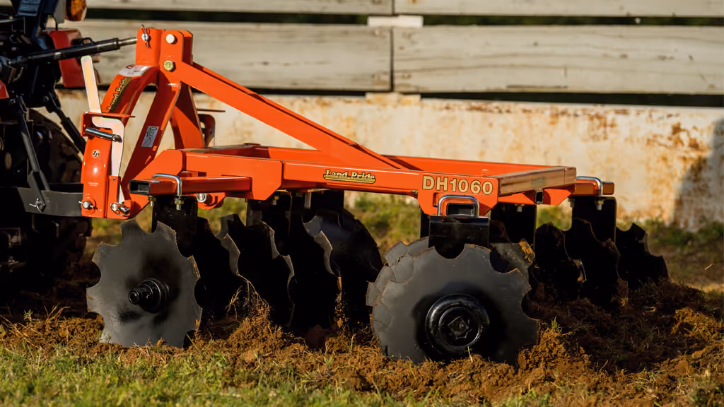 Orange disc harrow attachment with angled steel discs.
