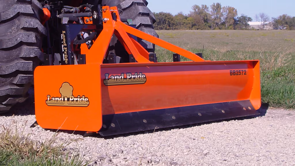 Orange grading attachment with wide steel blade.