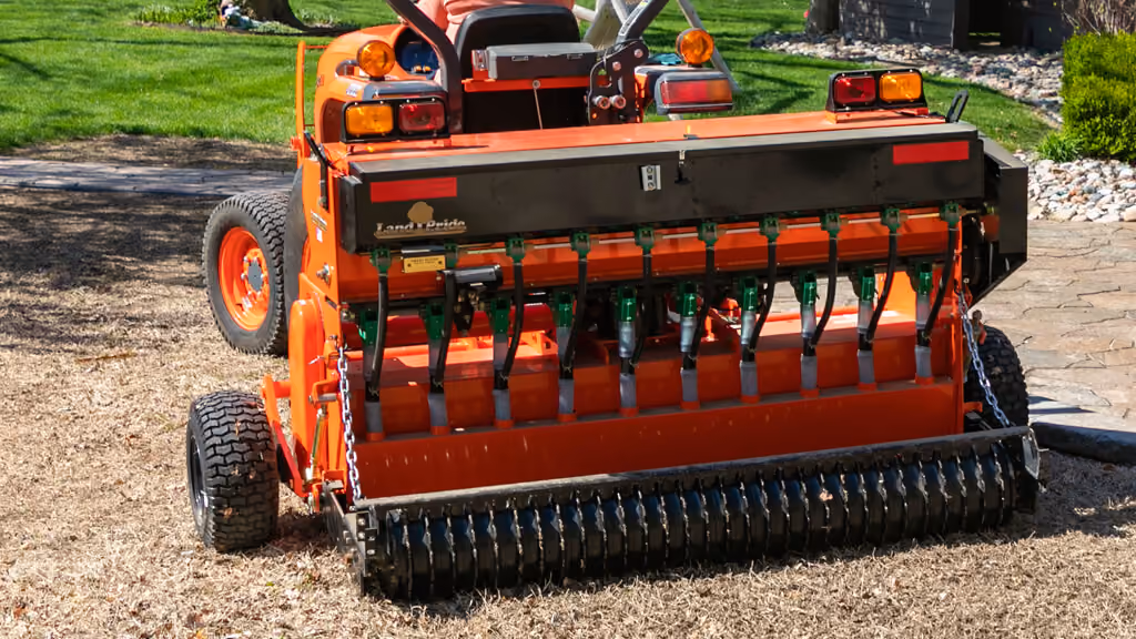 Orange seeder attachment for preparing and planting soil.