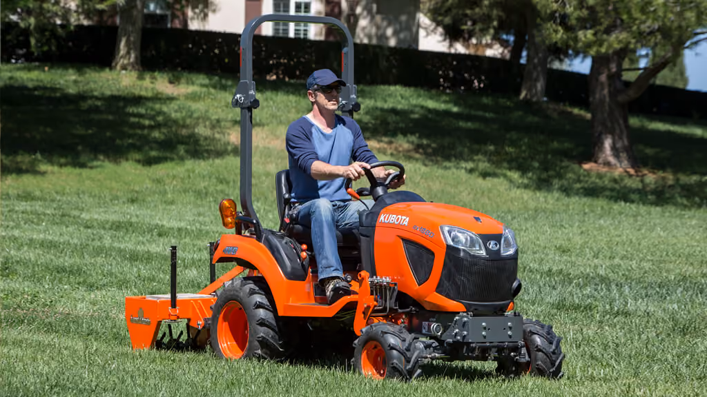 Orange Kubota tractor with roll-over protection.