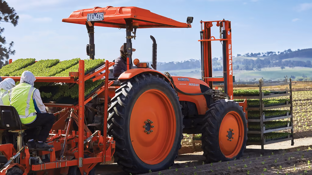 Orange Kubota tractor with roll-over protection.
